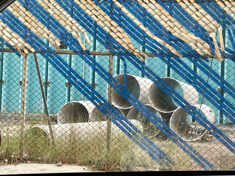 Tubos grandes visible detrás de una reja