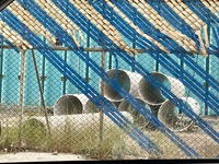 Tubos grandes visible detrás de una reja