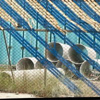 Tubos grandes visible detrás de una reja